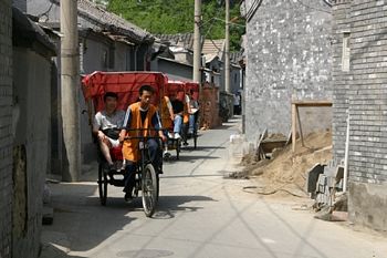 Groups of tourists ride through streets too narrow for automobiles