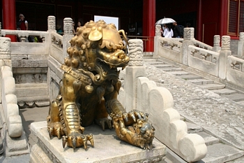 Female bronze lion with cub under foot