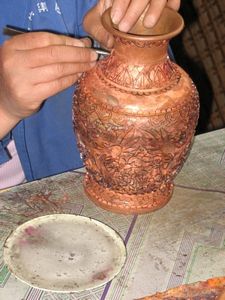 The first step is to soder curved wires to the vase to outline the design.